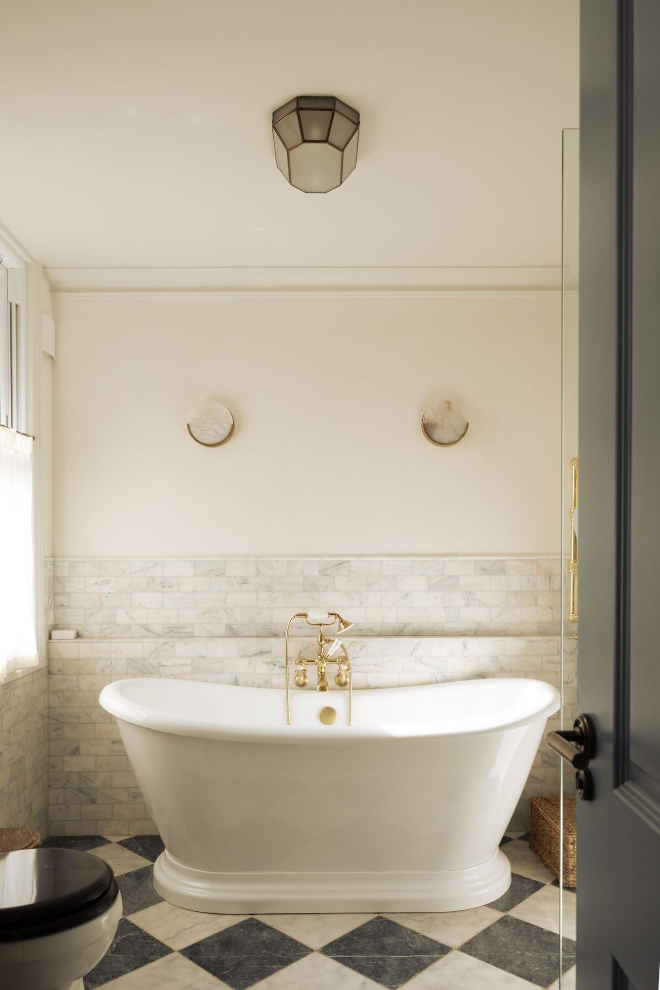 Roll top bath on a chequerboard marble floor