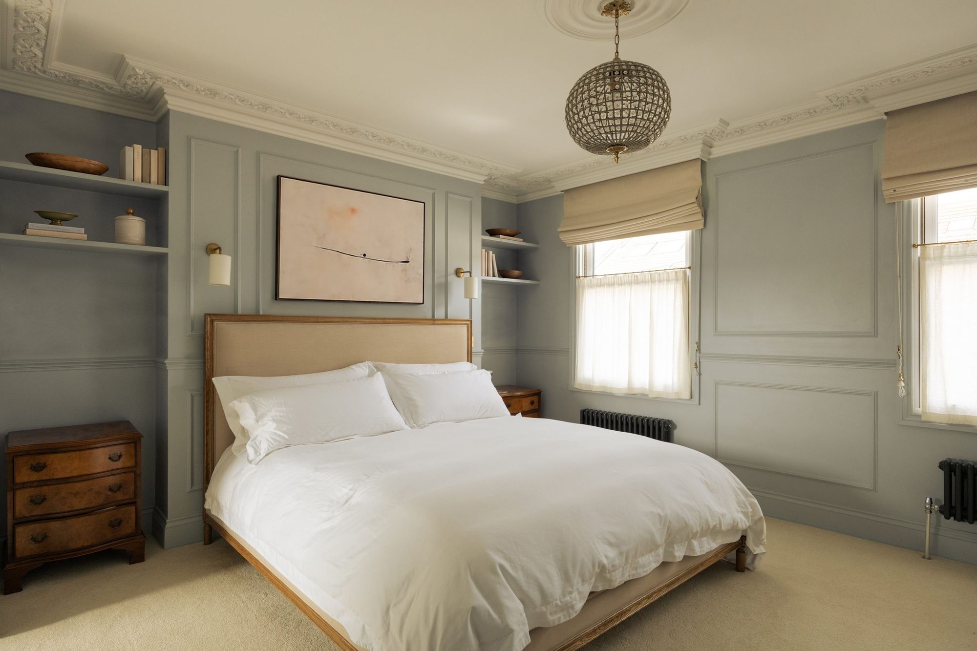Primary bedroom with panelled walls and alcove shelving