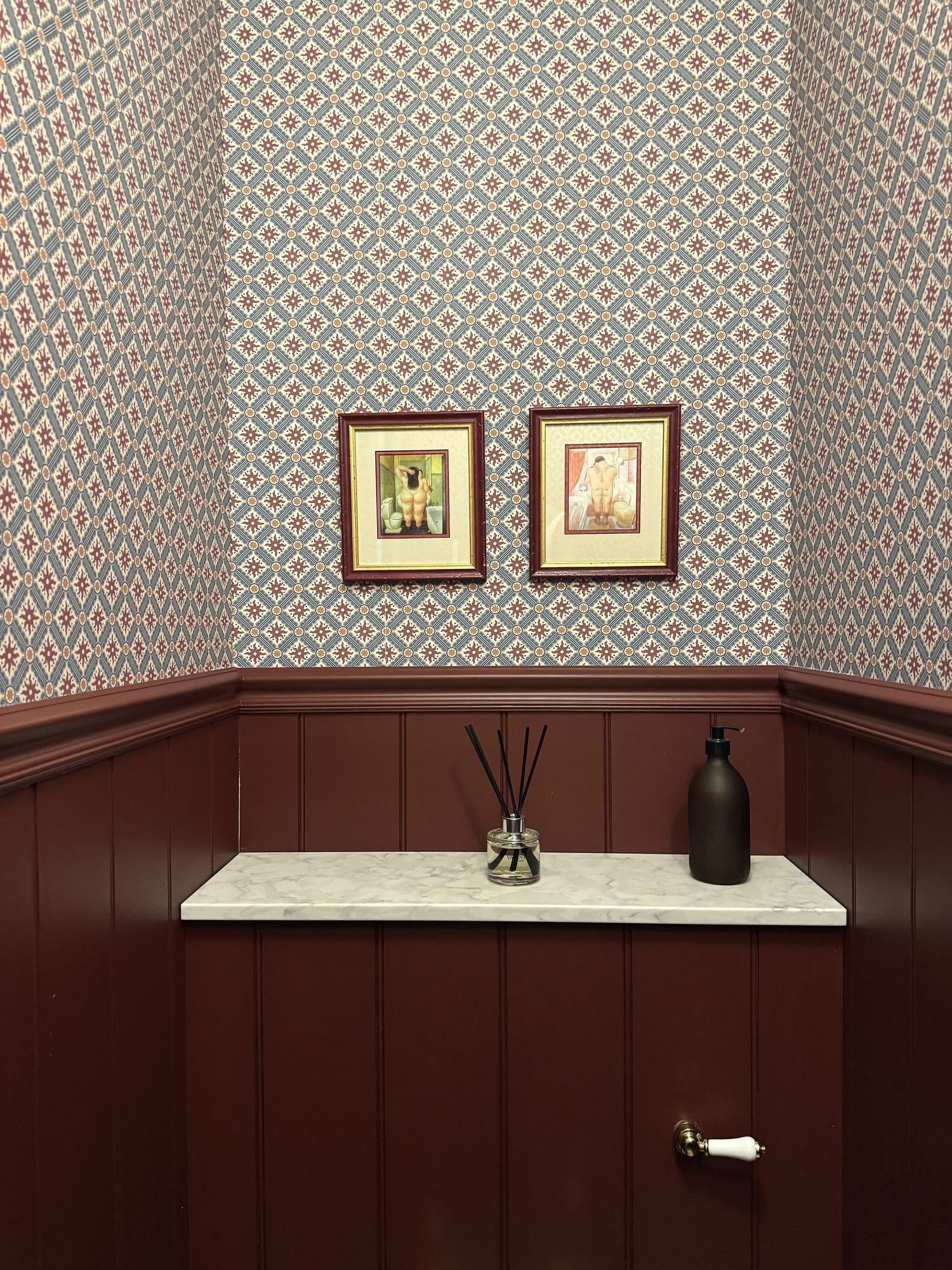Cloakroom with framed prints above burgundy panelling