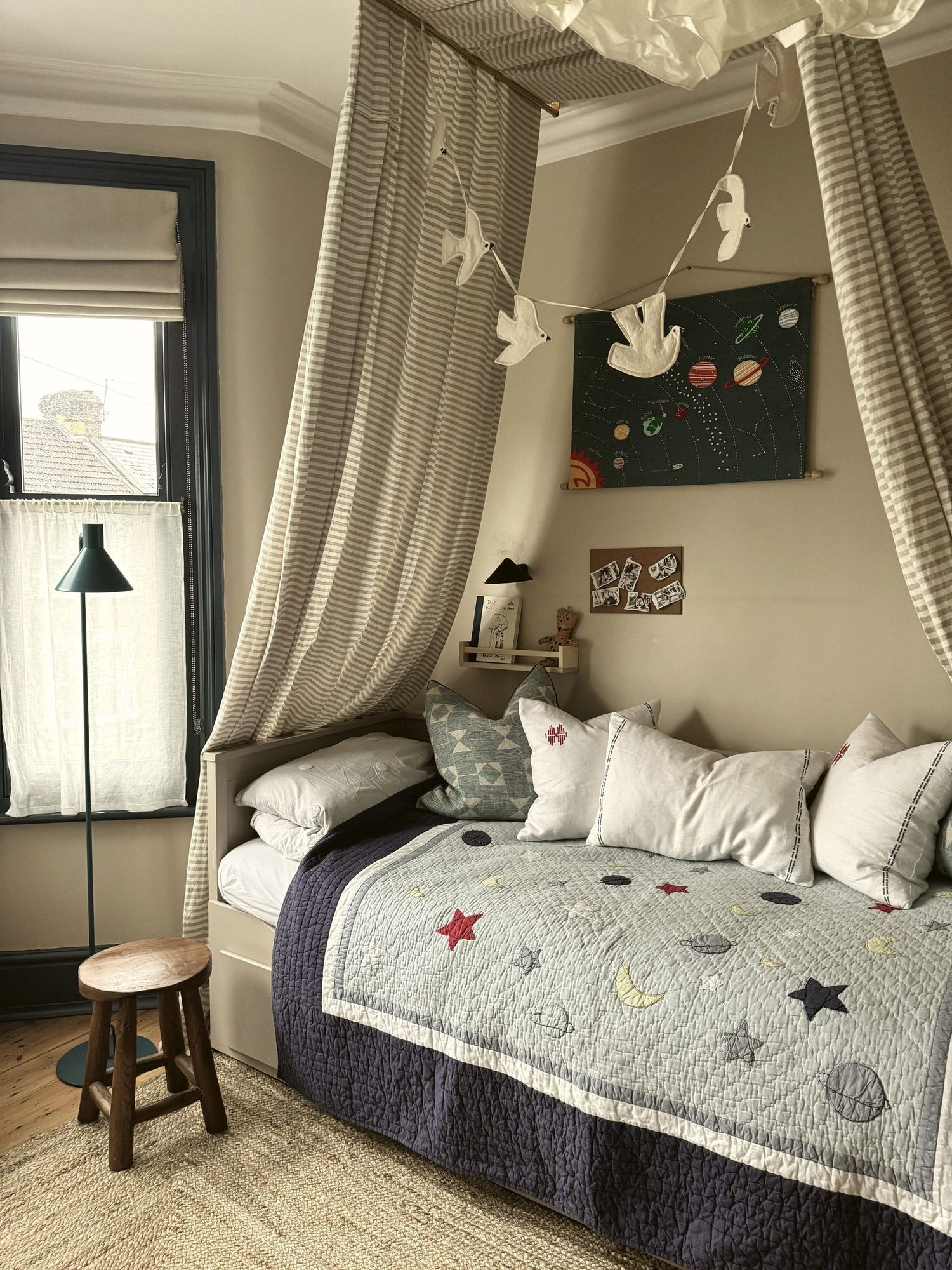 Child's bedroom with striped canopy over a daybed